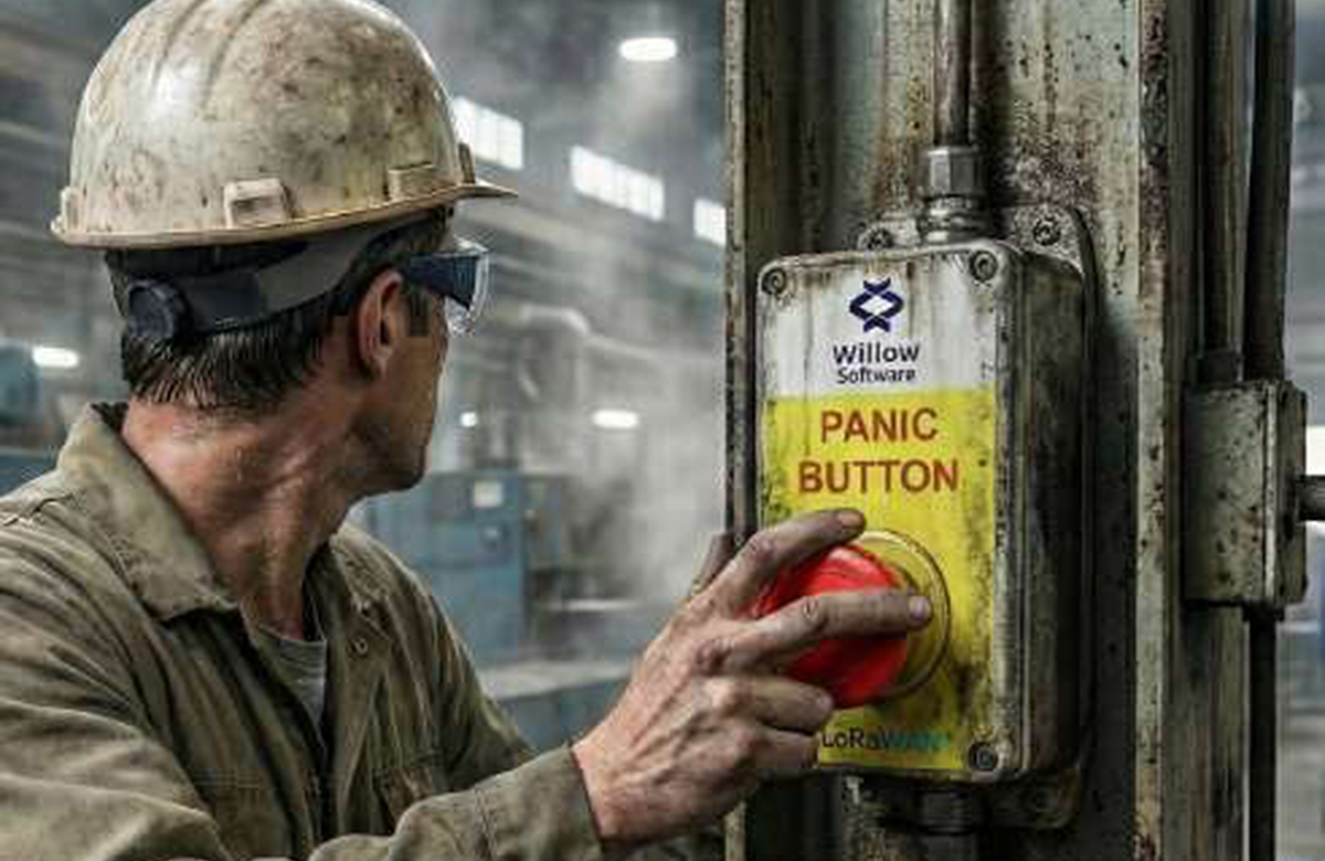 Worker activating an emergency panic button in an industrial setting.